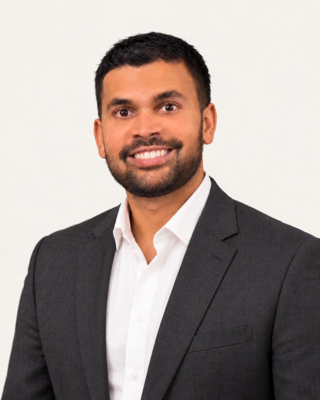 Portrait of Jinesh Shah, M.D., in a charcoal jacket and white shirt